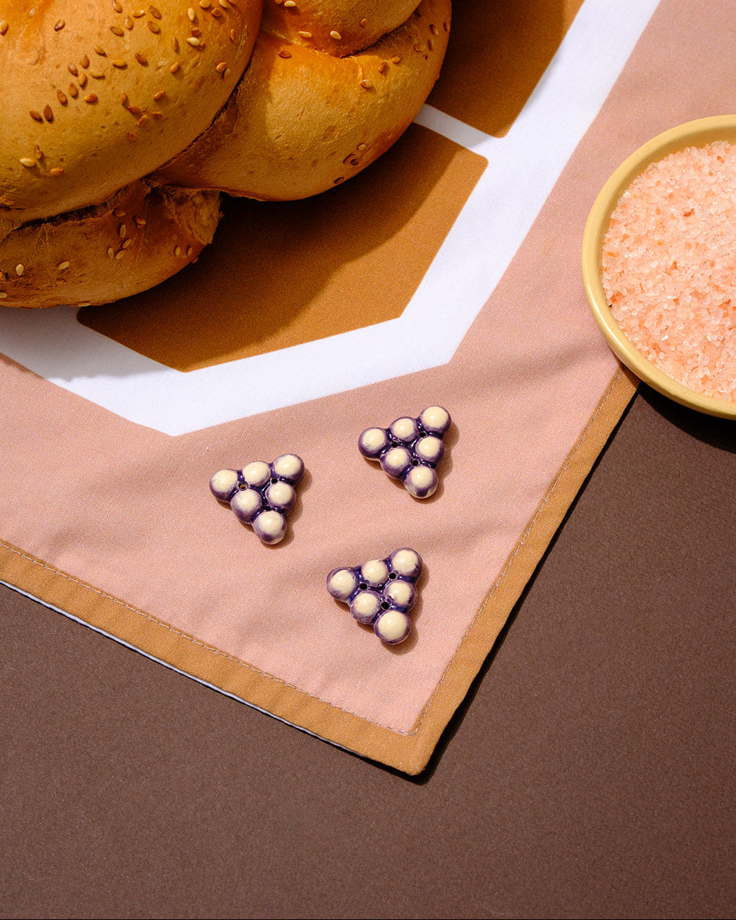 Minimalist Shabbat challah cover with ceramic grape beads and graphic Hebrew design, made to order in Israel.


