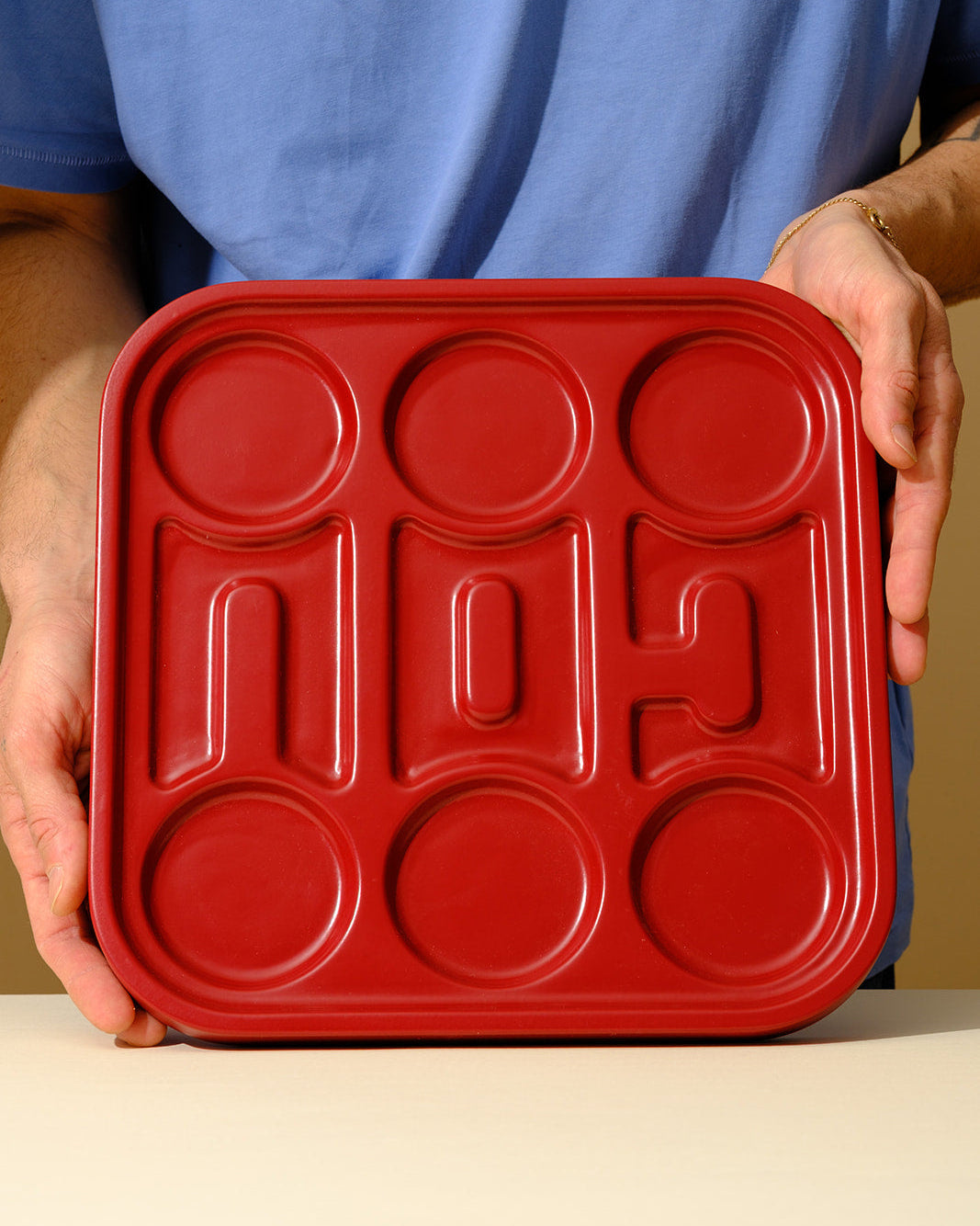 A handcrafted red wooden Seder plate featuring integrated ceramic bowls, designed as a contemporary interpretation of the traditional Passover ritual object