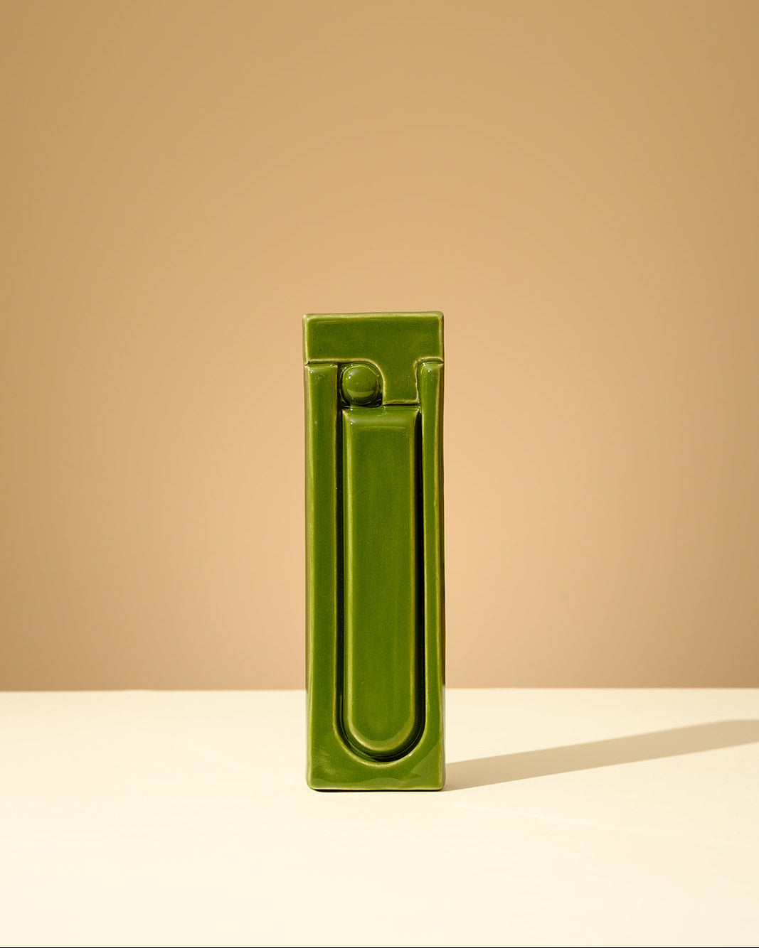 Handmade ceramic mezuzah in glossy olive green glaze with a minimalist geometric Hebrew letter design
